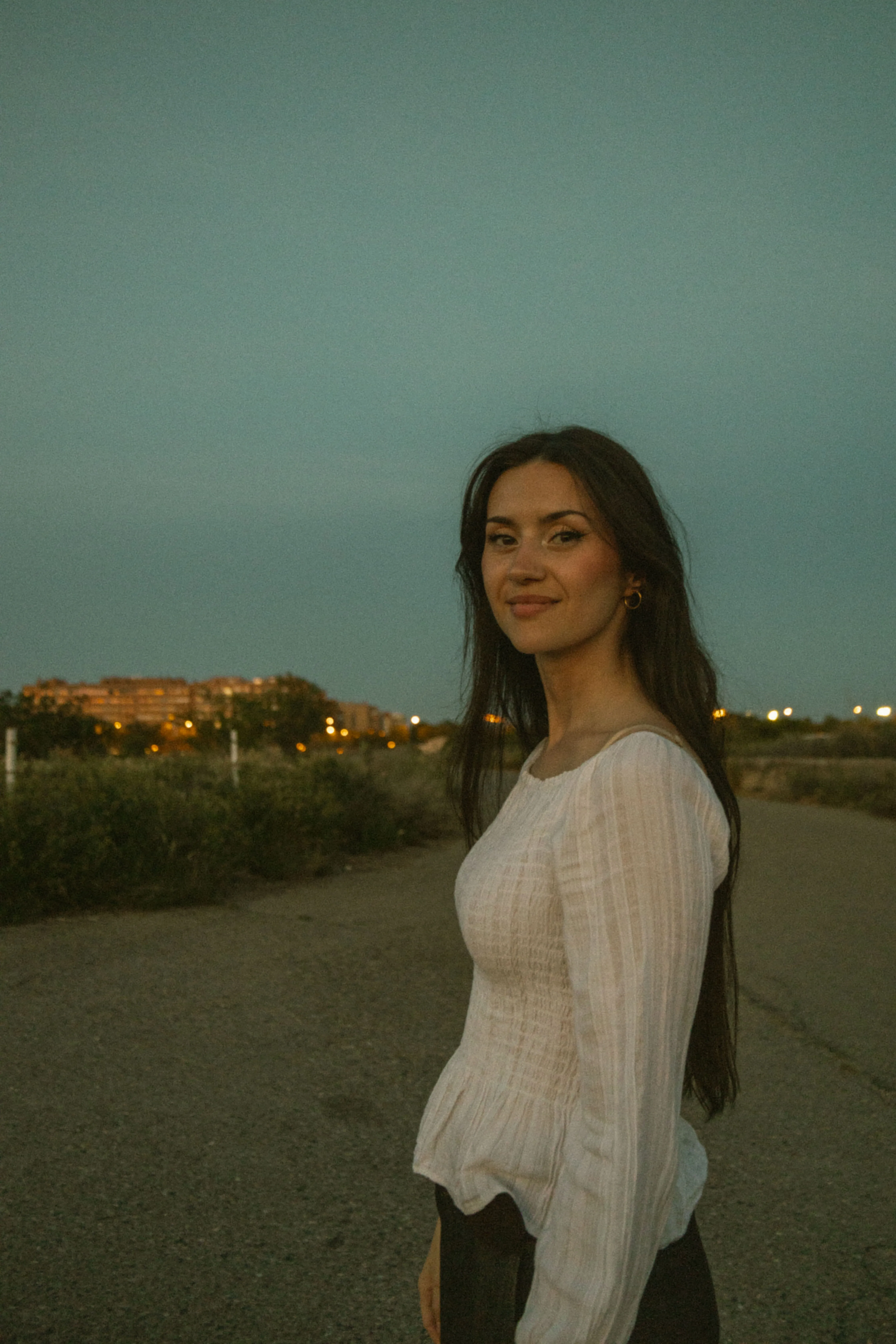 Paula caminando en el campo al atardecer.