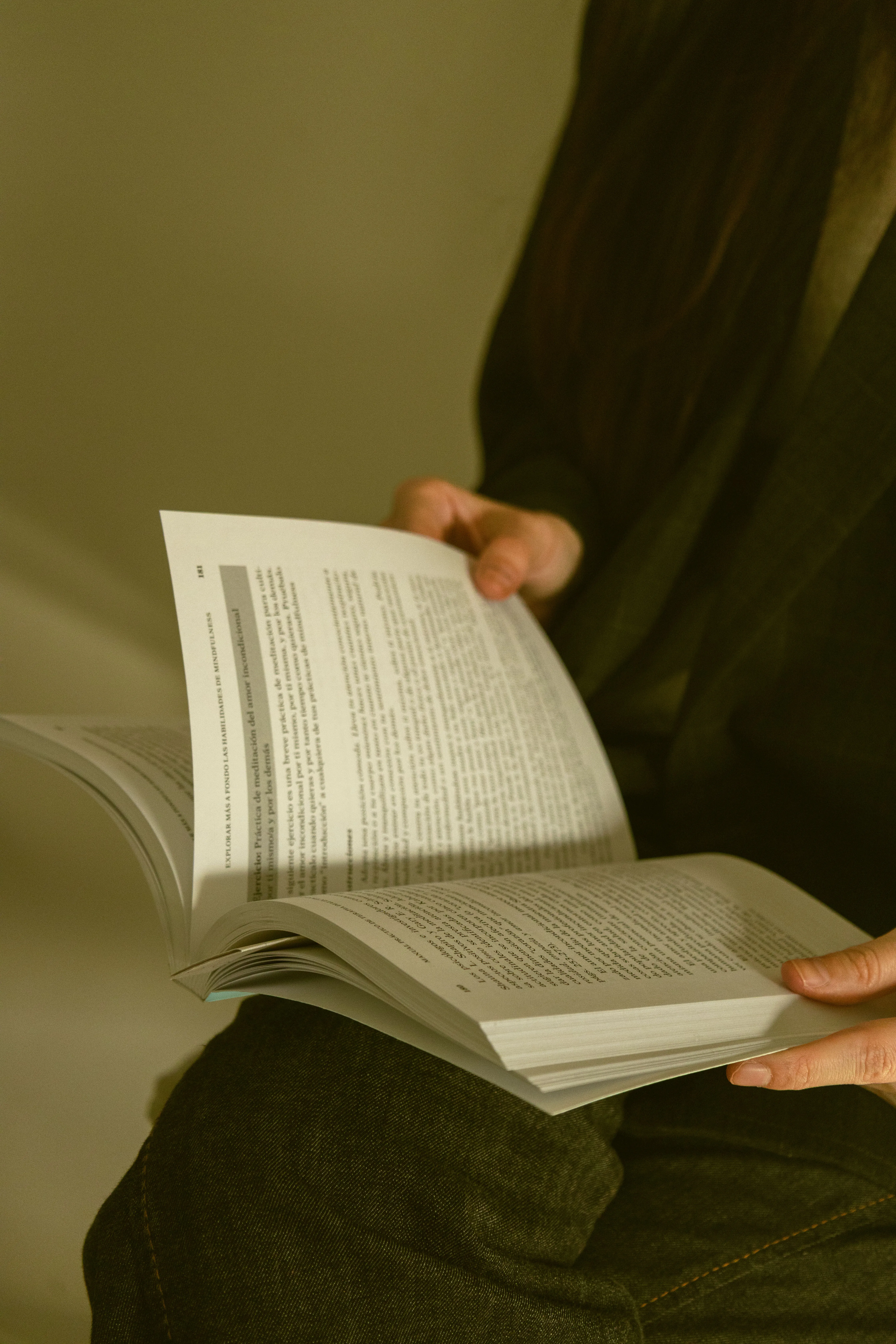 Paula con un libro abierto en el regazo.